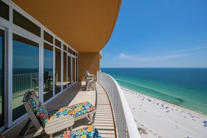 A balcony with a view of the ocean, a beach, and a pool area with lounge chairs. - Phoenix Gulf Towers 1803 | Gulf-Front 3BR  Pool, Lazy River & Beach (Orange Beach)