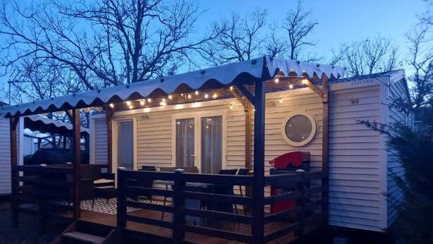 A mobile home with a covered deck, a front door, and a circular window. - 🌞 Rent Mobil-Home all comfort - Near Lac de Sainte-Croix 🌿 (Sainte-Croix-du-Verdon)