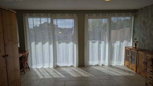 A room with a large sliding door, a wooden cabinet, and a tiled floor. - Vacation apartment Waldbronn 1 person (Waldbronn)