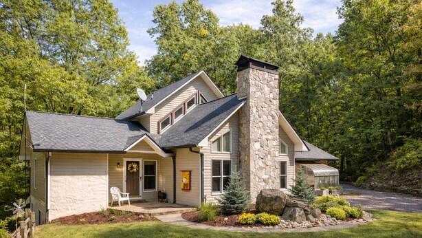 A two-story house with a stone chimney, a front porch, and a well-maintained lawn. - Solace Mountain Cozy Mountain Retreat with Game Room, sleeps 9, Wifi, private (Franklin)