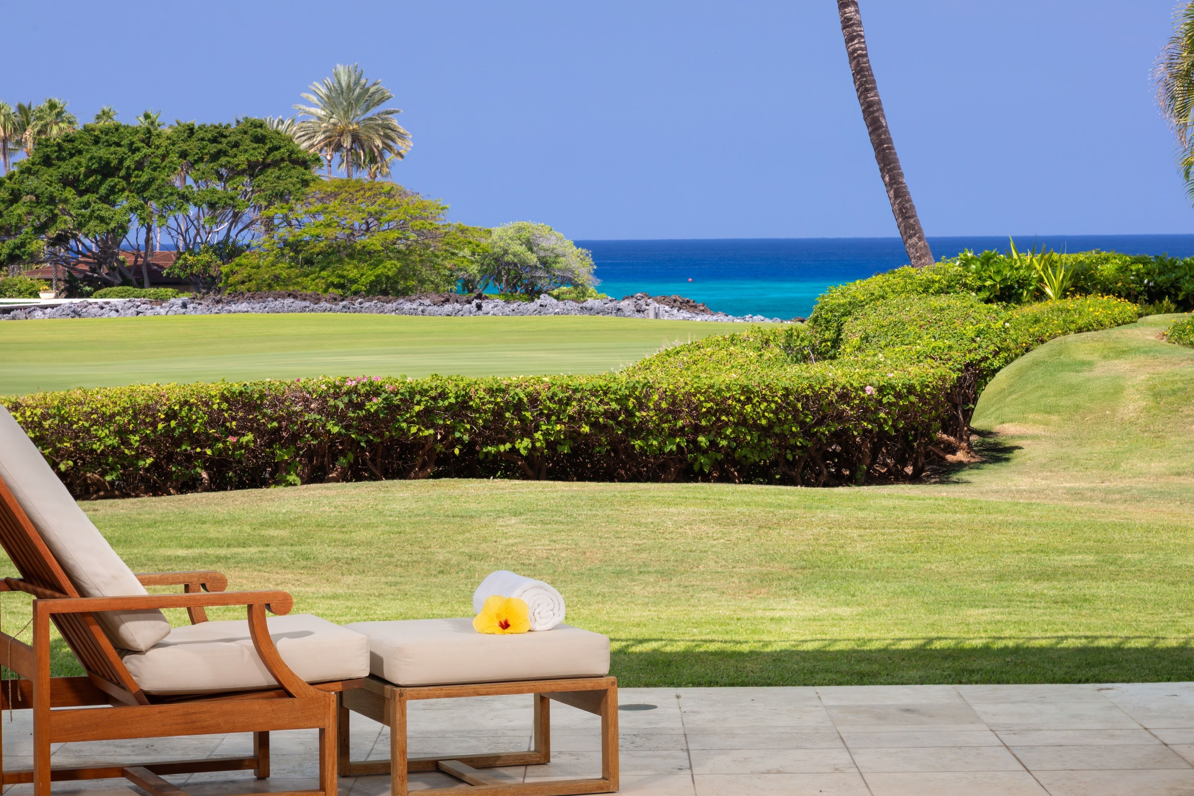 Luxurious oceanfront golf course setting with pristine landscaping, tropical palms, and azure waters creating an idyllic Hawaii escape.