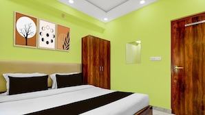 Een slaapkamer met een bed, een kledingkast, een spiegel en wanddecoratie.