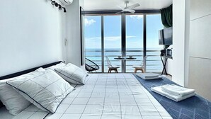 A modern hotel room with a large bed, a TV, a ceiling fan, and a view of the ocean. - Mediterranean Dream Calpe (Calp)