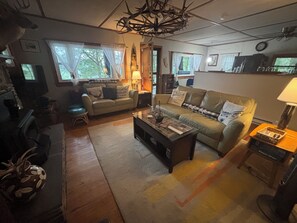 Een woonkamer met een bank, salontafel en televisie.