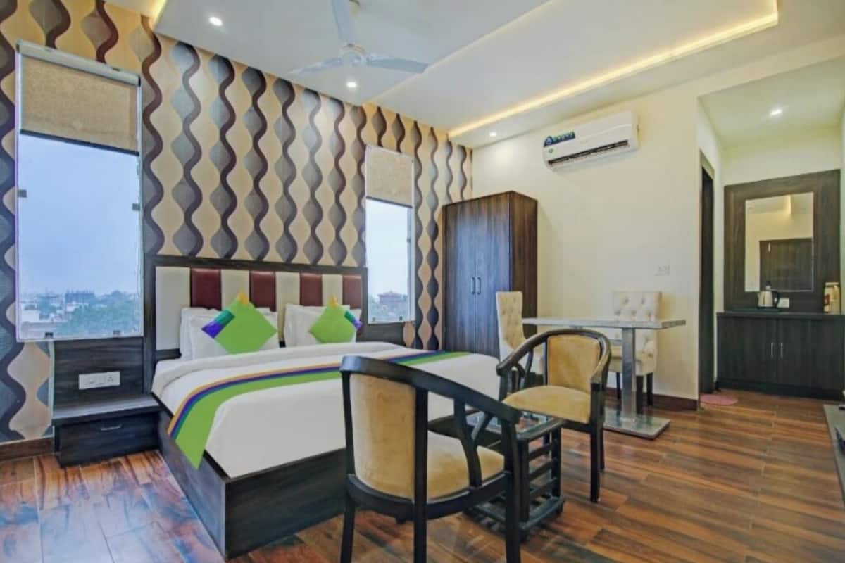 Hotelkamer met een bed, een bureau, een stoel, een kledingkast en een airconditioning.