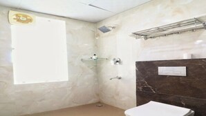 Een badkamer met een toilet, douche en wastafel.