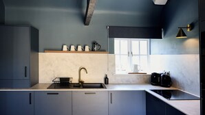 Una cocina moderna con estufa integrada, un lavamanos y ventana con vistas.