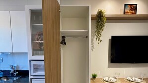 Eine moderne Küche mit integriertem Geschirrspüler, ein Essbereich mit Fernseher und eine Treppe zu einem Dachbodenraum.