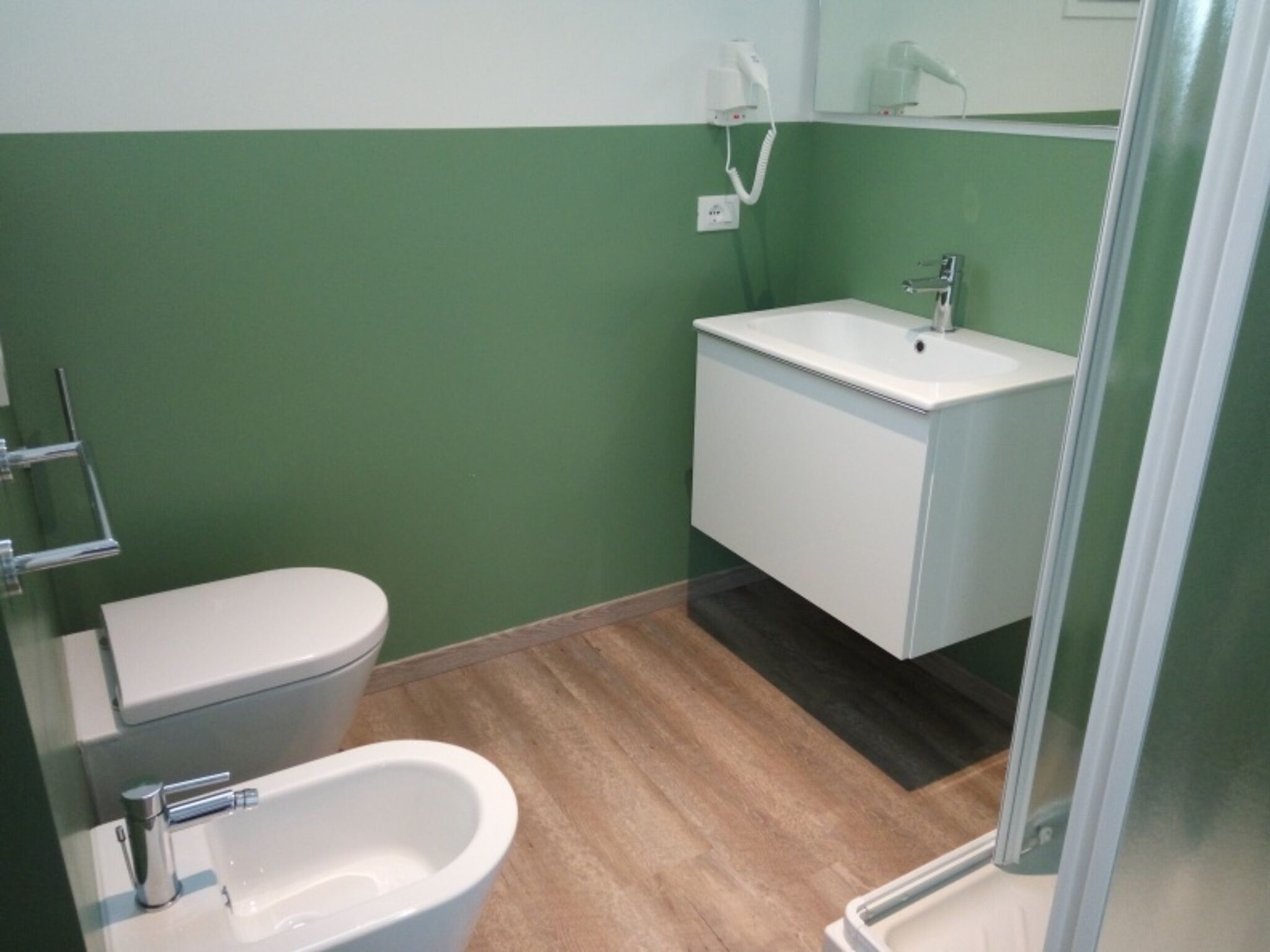 A bathroom with a toilet, bidet, and sink.