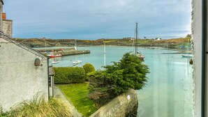 Une vue sur la côte, avec des bateaux, un phare et une zone herbeuse.