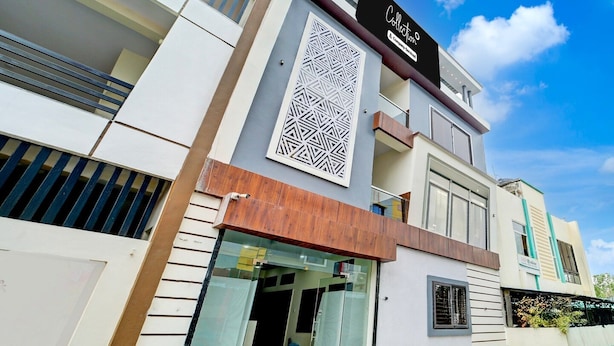 A modern building with a prominent sign, a geometric decorative panel, and a glass entrance. - Deluxe Hotel Sp14 (Indore)