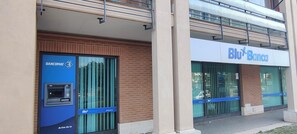 A bank with a blue ATM and a sign that reads 'Blu Banca'. - LeonardoHome-FCO Airport & Exhibition Center (2 min by train)/Rome (25 min by train)   (Lazio)