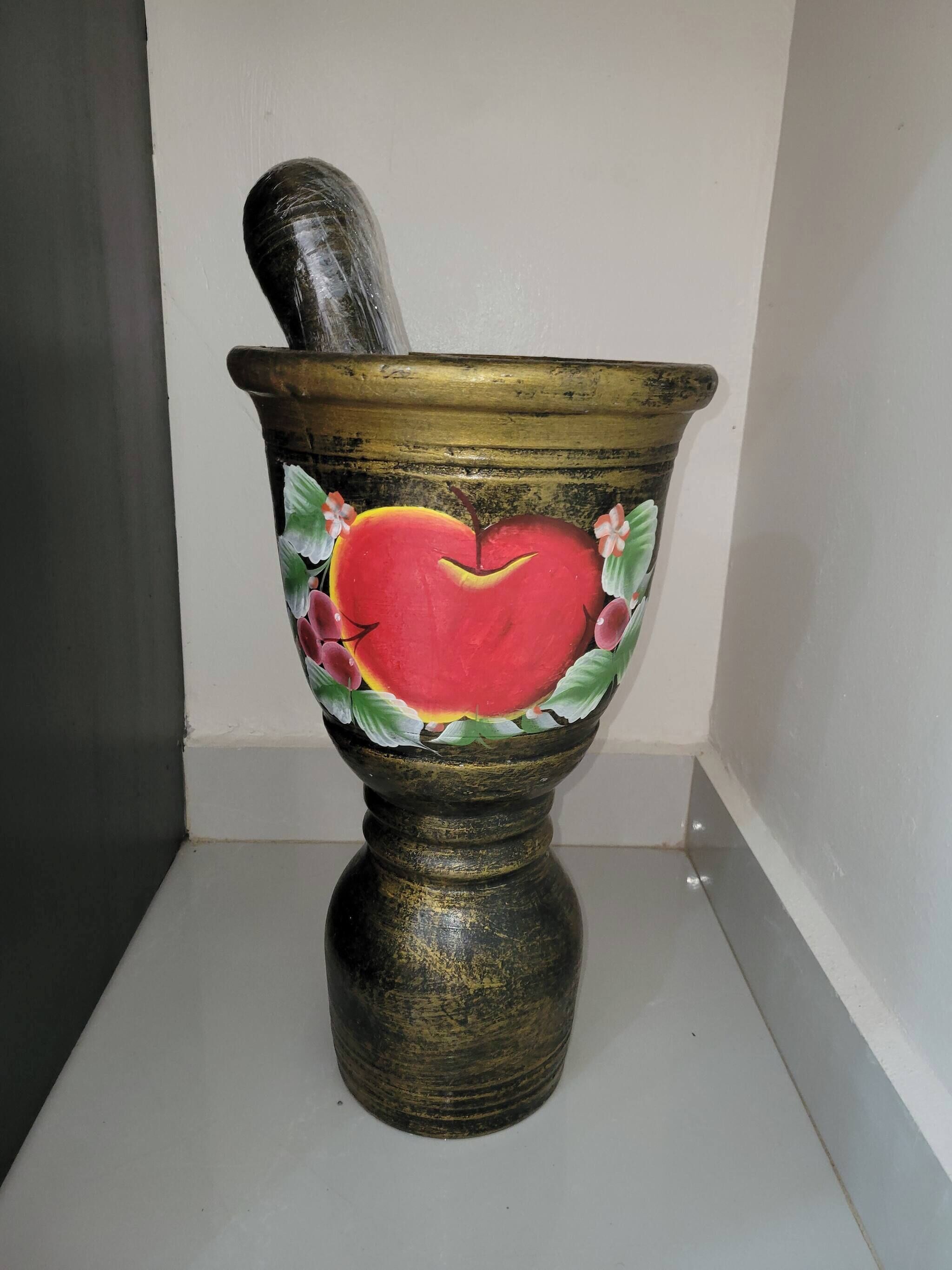 En rustik, antik mortel med ett målat hjärta och ett blommönster.