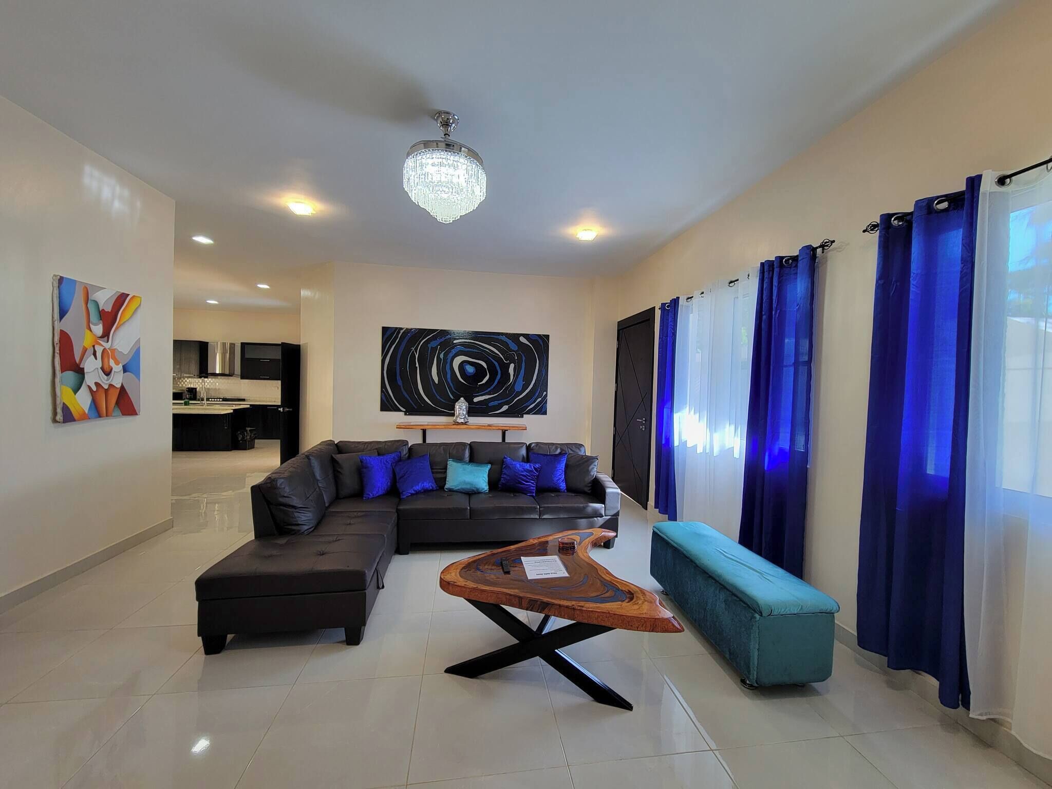 A modern living room with a sectional sofa, a coffee table, and a large abstract painting.