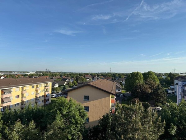 Un quartier résidentiel avec des immeubles à plusieurs étages, un ciel dégagé et des arbres.