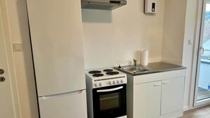 A compact kitchen with a refrigerator, stove, oven, and a small countertop.