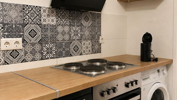 A kitchen with a stove, oven, dishwasher, and washing machine. - Well-kept apartment for fitters & project teams with 2 bedrooms in Mannheim (Mannheim)