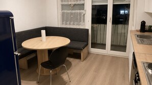 A compact kitchen with a round table, a bench, and a stove. - Well-kept apartment for fitters & project teams with 2 bedrooms in Mannheim (Mannheim)