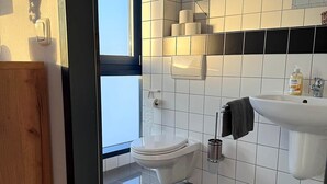 Ein modernes Badezimmer mit Toilette, Waschbecken und Handtuchhalter.