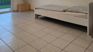 A bedroom with a bed, a nightstand, a lamp, and a ceiling light fixture. - Worker's apartment Rheinhausen (ground floor) (Oberhausen-Rheinhausen)