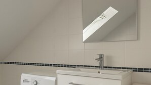 A laundry area with a washing machine, a sink, and a mirror. - Fitters' apartment Oberhausen-Rheinhausen, Lönsweg 3, DG (Oberhausen-Rheinhausen)