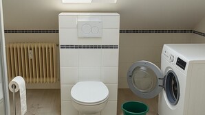 A compact bathroom with a skylight, a toilet, a washing machine, and a green bucket. - Fitters' apartment Oberhausen-Rheinhausen, Lönsweg 3, DG (Oberhausen-Rheinhausen)