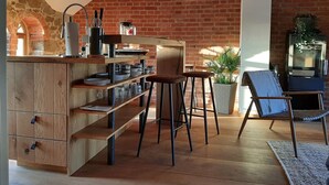 Eine Küche mit Backsteinwand, Holzschränken und einer Bar mit Hockern.