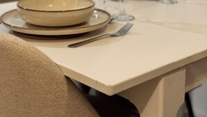 A dining table with plates, glasses, and cutlery.