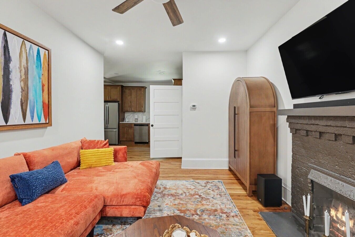 A living room with a sofa, a fireplace, and a television.