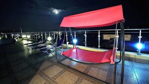 A rooftop terrace with a red canopy seating area, a pool, and a railing. - BLUE PEARL 2-BEDROOM LUXURY MAISONETTE IN PANORAMIC ROOF COMPLEX (Balchik)