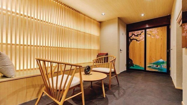 Een kamer met een houten vloer, een houten scheidingswand en een traditionele Japanse glijdeur met bloesemblad ontwerp.