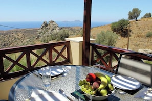 Ein Tisch mit Blick auf die Landschaft, eine Obstschale und ein Glas Wasser.