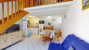 A compact living space with a kitchen, dining area, and a sofa. - Villa Aquatica (Saint-Hilaire-de-Riez)