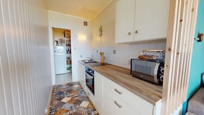 Una cocina compacta con microondas, tostadora y lavabo.