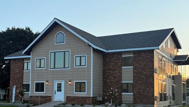 A two-story house with a brick facade, multiple windows, and a front entrance. - Mushroom Cap Motel (Mesick)