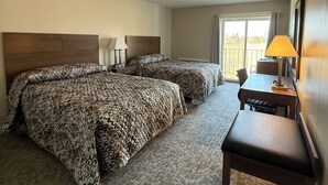 A hotel room with two beds, a desk, a chair, and a window with a view. - Mushroom Cap Motel (Mesick)