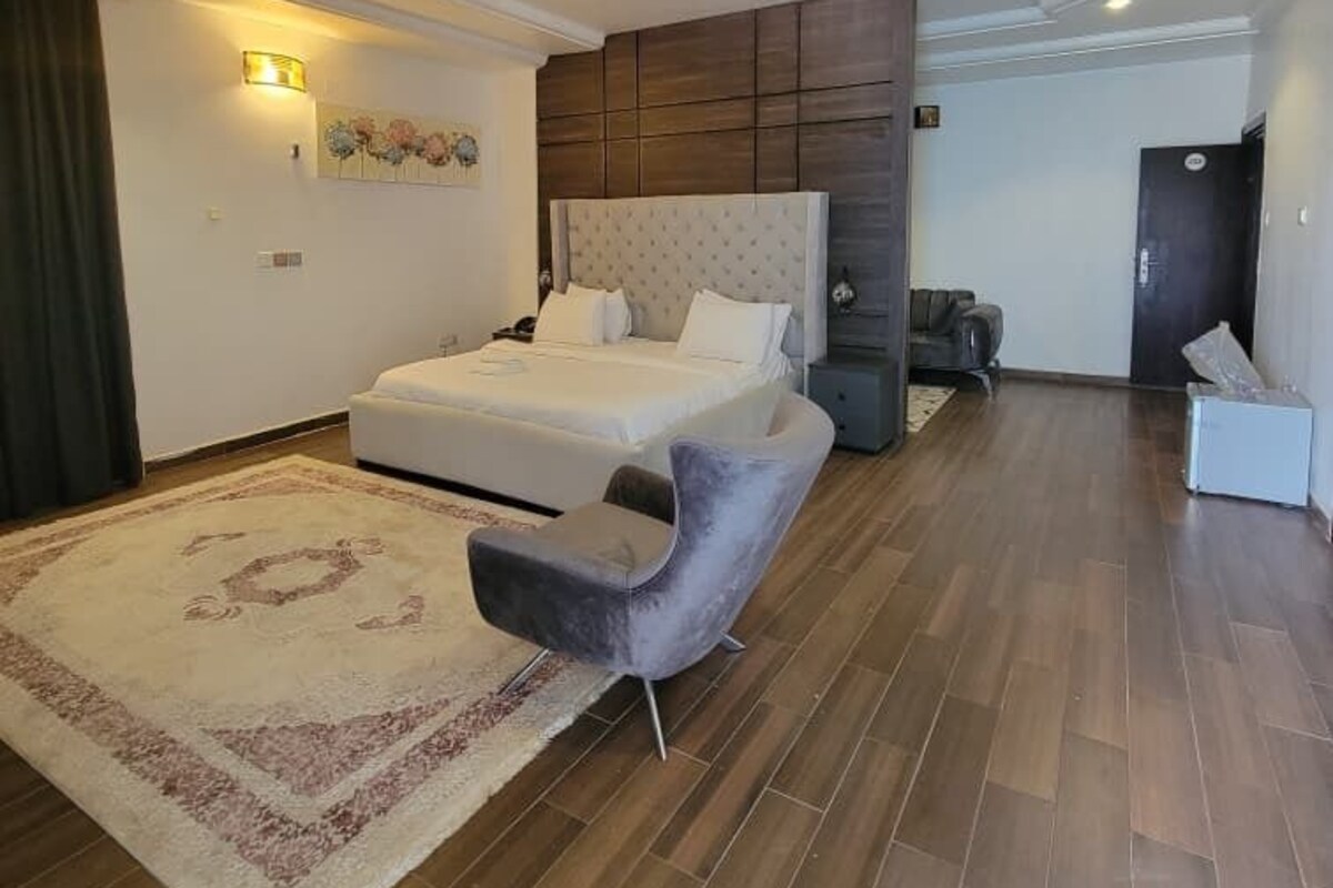 Un dormitorio moderno con una cama grande, un tocador y una zona de estar.