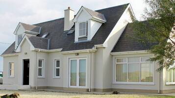 A two-story house with a gabled roof, multiple windows, and a front door.