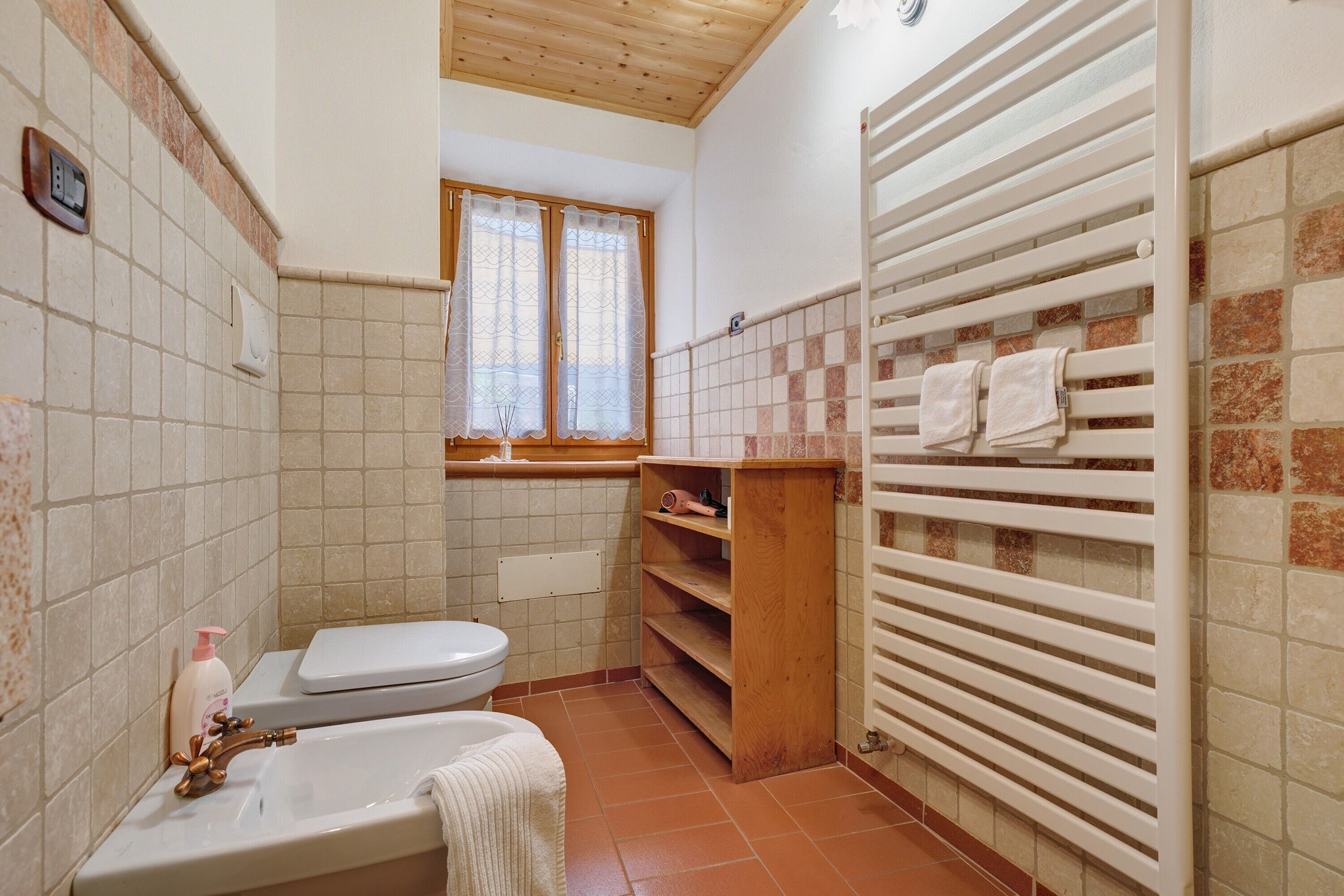Un baño con inodoro, lavamanos y toallero.