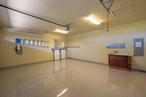 A spacious room with a polished floor, ceiling-mounted lighting, a projector, a whiteboard, and a wooden cabinet. - Wai'ula'ula Villa 345 Three Bedroom (Kohala Coast)