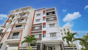 Un edificio residencial de varios pisos con un letrero que indica que cuenta con servicios de OYO.