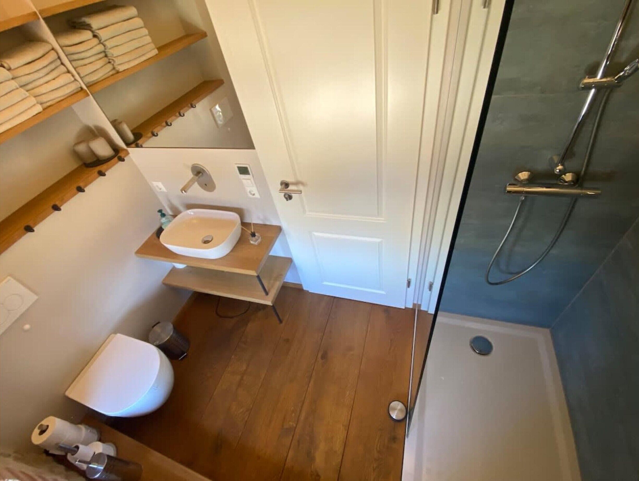 A bathroom with a toilet, sink, and shower.
