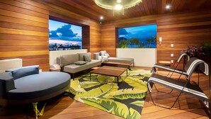 Ein modernes Wohnzimmer mit Holzwänden, einer Couch, einem Couchtisch und Blick auf die Stadt durch große Fenster.
