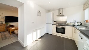 A modern kitchen with a built-in oven, a refrigerator, and a stove. - Fionas Cottage -  a house that sleeps 6 guests  in 3 bedrooms (Crieff)