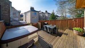 A wooden deck with a hot tub, outdoor seating, and a wooden fence. - Fionas Cottage -  a house that sleeps 6 guests  in 3 bedrooms (Crieff)