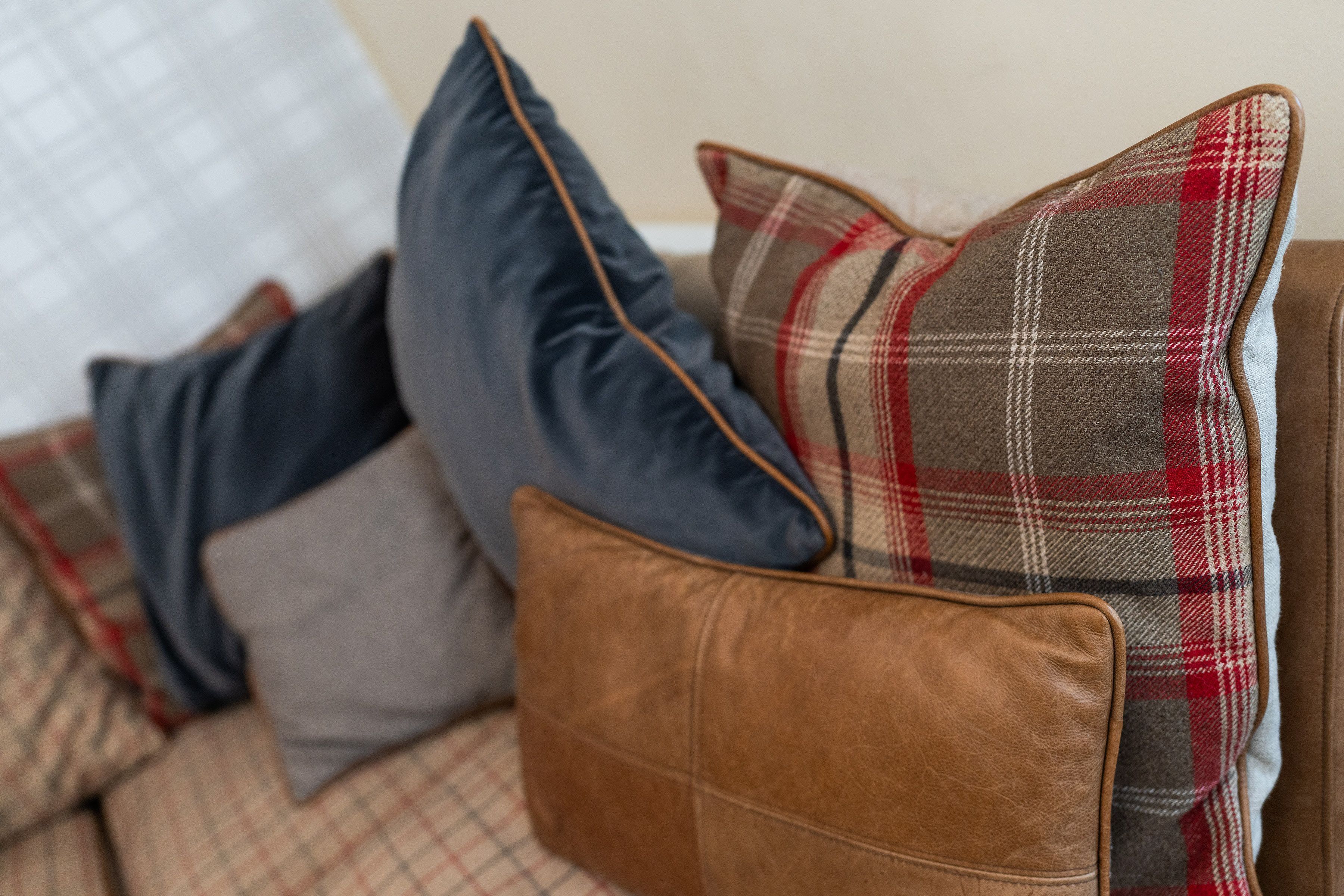 A sofa with multiple cushions in various patterns and colors.