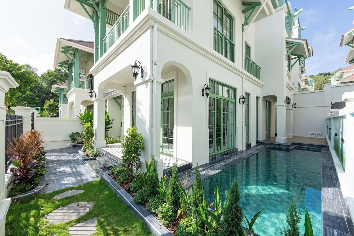 A modern house with a swimming pool, green shutters, and a well-maintained garden.