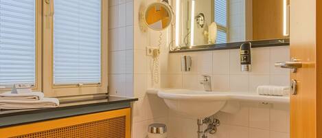 A bathroom with a sink, mirror, towel rack, and window blinds.