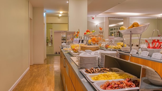 Un buffet proposant une variété de plats, notamment des fruits, des légumes et des viandes.