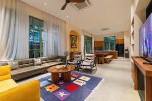 A modern living room with a sofa, chairs, a coffee table, and a TV. - Opus Villas Tropical Phu Quoc (Phu Quoc)